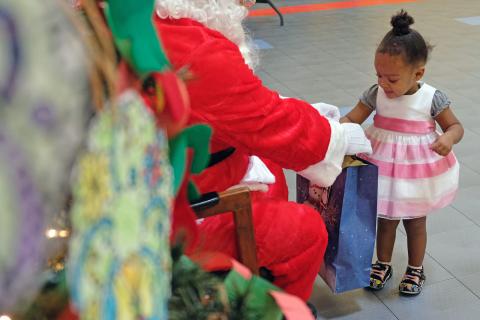 A child receives a gift from Santa.
